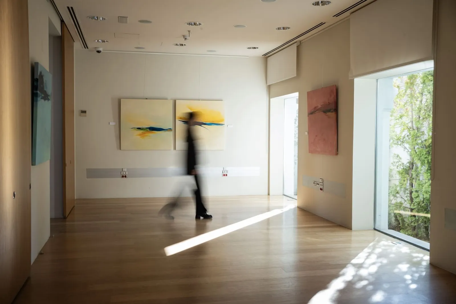 Bright exhibition hall with paintings and large windows at Fundación Pons in Madrid