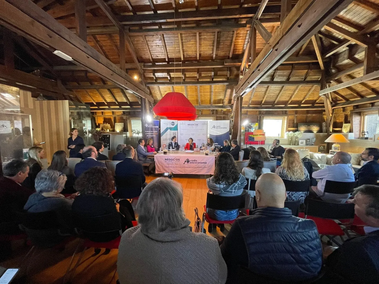 Conference hall with timber beams and audience at Fundación Pons in Madrid