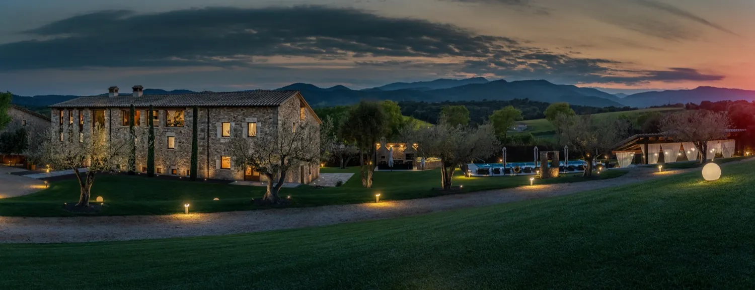The farmhouse at dusk, surrounded by gardens